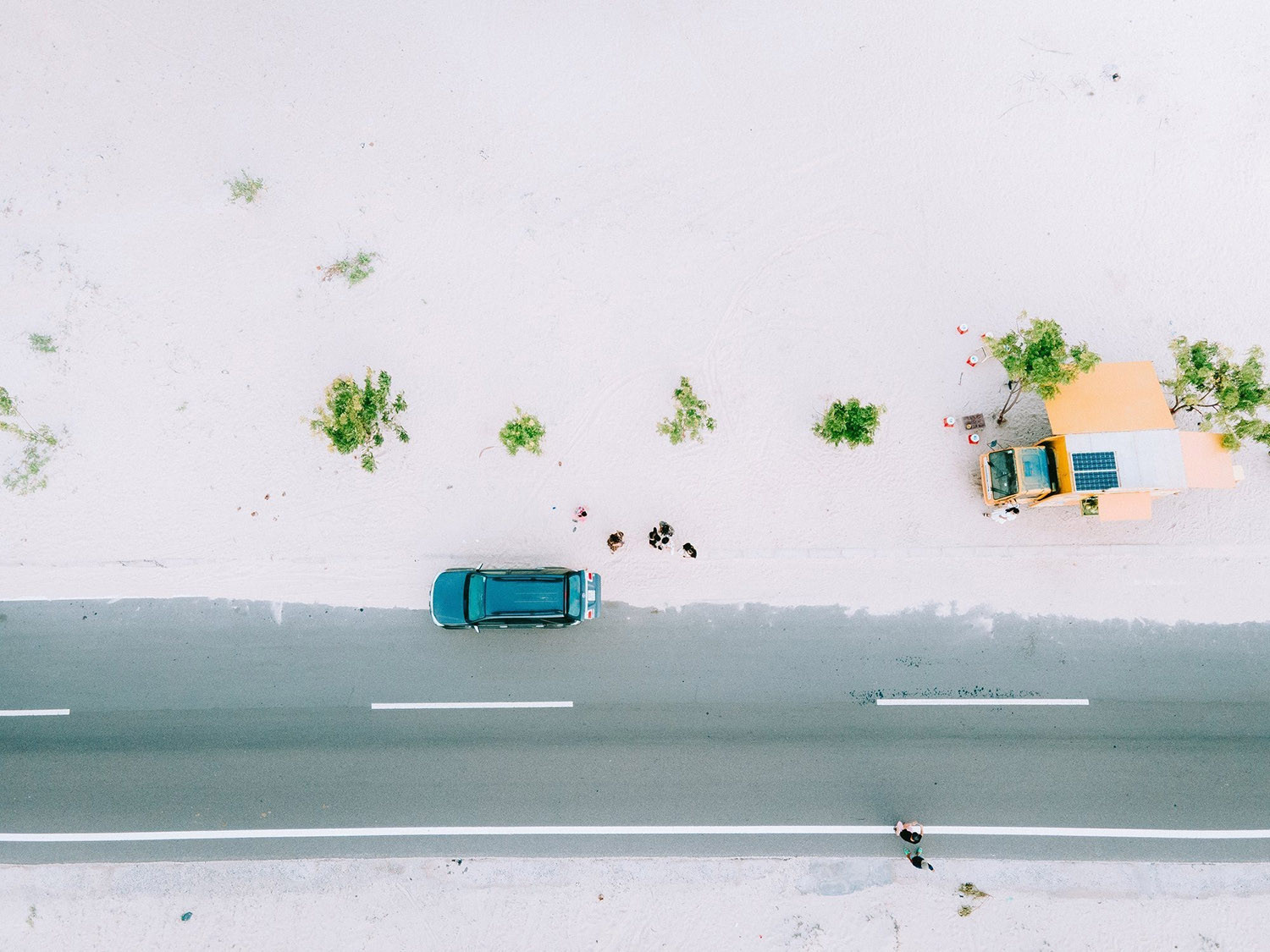 Chiếc xe bán đồ ăn màu vàng đậu bên đường cát