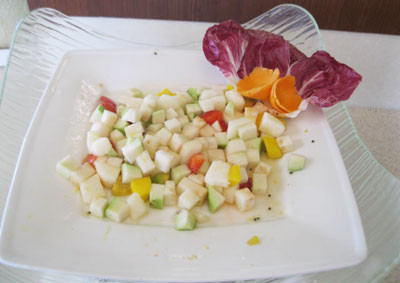 Đĩa gỏi trái cây đầy màu sắc được bày biện đẹp mắt, chứa các loại quả như xoài, dâu tây, bơ và ổi.