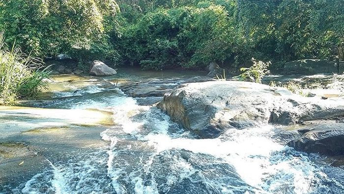 Dòng nước chảy qua những tảng đá bằng phẳng tại thác trượt Tà Pứa