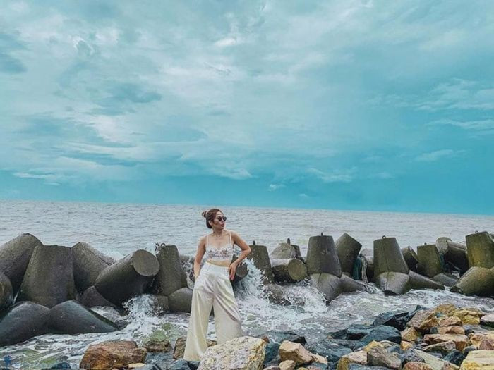 Du khách chụp ảnh lưu niệm bên những ghềnh đá và sóng biển tại Bãi đá Ông Địa