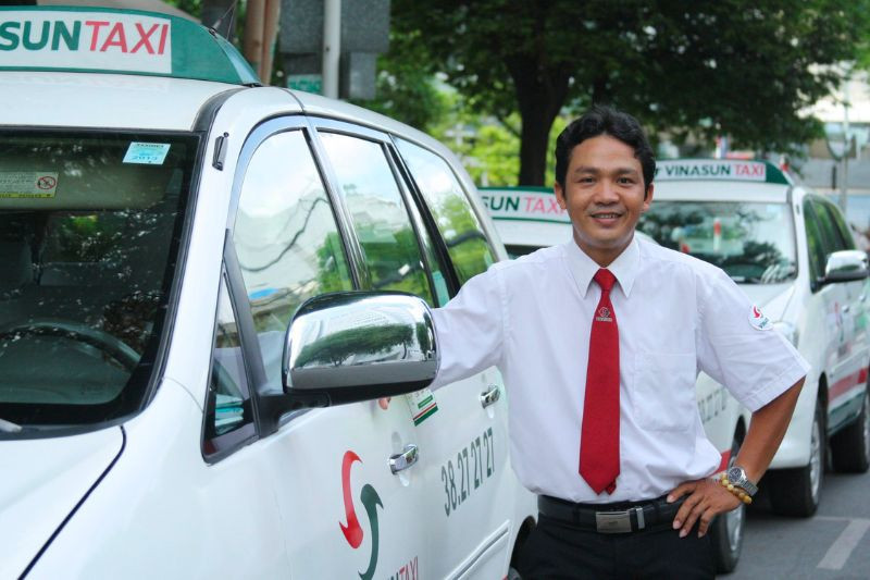Đội ngũ tài xế taxi Vinasun với đồng phục chuyên nghiệp và xe màu trắng, phục vụ tại Phan Thiết