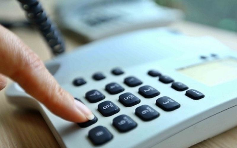 Người phụ nữ nhìn vào màn hình điện thoại với biểu tượng chặn cuộc gọi, tượng trưng cho việc tra cứu và quản lý số điện thoại làm phiền.