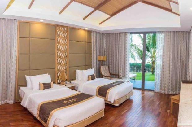 Phòng ngủ tại Sonata Resort &amp; Spa Phan Thiết có ban công rộng lớn với view vườn nhiệt đới xanh tươi.