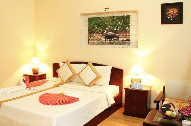 Phòng ngủ tại Tiến Đạt Resort &amp; Spa Mũi Né với gam màu vàng nhạt, mang đến cảm giác ấm áp và sang trọng.