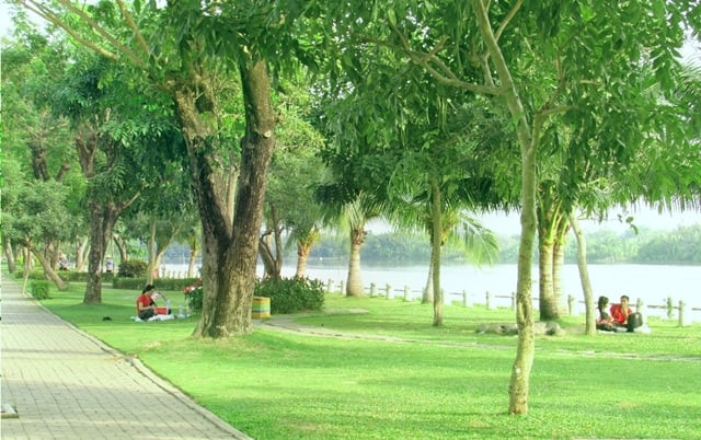 Thảm cỏ xanh mướt và không gian yên bình tại công viên Hồ Bán Nguyệt